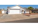 Single-story house with gray exterior, white garage door, and a palm tree in the front yard at 7210 W Pasadena Ave, Glendale, AZ 85303