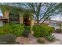 Front view of a two-story home with stone pathway, lush landscaping, and a balcony at 7846 E Mackenzie Dr, Scottsdale, AZ 85251