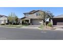 Attractive home with a welcoming porch and a spacious two-car garage, surrounded by lush greenery at 9750 E Radioactive Dr, Mesa, AZ 85212