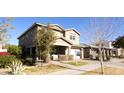 Two-story house with tan siding, landscaping, and walkway at 9750 E Radioactive Dr, Mesa, AZ 85212