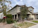 Two-story house with beige exterior, attached garage, and landscaping with desert plants at 9750 E Radioactive Dr, Mesa, AZ 85212