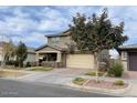 Two-story house with beige exterior, attached garage, and a tree in front at 9750 E Radioactive Dr, Mesa, AZ 85212