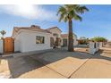 Newly remodeled home with a large driveway and a wood gate at 9821 E University Dr, Mesa, AZ 85207