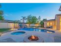 Resort-style backyard oasis with a pool, spa, and fire pit at 9825 E Sharon Dr, Scottsdale, AZ 85260