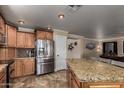 Kitchen area with granite countertop island and stainless steel refrigerator and cabinets at 11346 E Renata Ave, Mesa, AZ 85212
