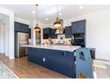 Modern kitchen with blue cabinets, island, and stainless steel appliances at 19087 E Walnut Ct, Queen Creek, AZ 85142