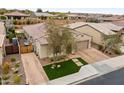 An elevated shot showcases the charming home's tile roof, paved driveway, and landscaping at 25891 N 104Th Dr, Peoria, AZ 85383