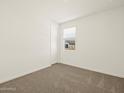 Bright bedroom features neutral carpet, a window with blinds, and fresh, clean walls at 37073 W La Paz St, Maricopa, AZ 85138