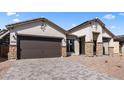 Attractive single-story home featuring stone accents, a paver driveway, and a low-maintenance desert landscape at 42104 N Golden Trl, San Tan Valley, AZ 85140