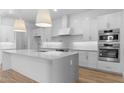 Bright, modern kitchen with white cabinetry, a large island, stainless steel appliances, and pendant lighting at 42104 N Golden Trl, San Tan Valley, AZ 85140