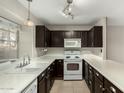 Modern kitchen with dark cabinets and white appliances at 7905 W Thunderbird Rd # 309, Peoria, AZ 85381