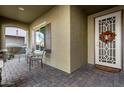 Covered front porch with two chairs and a fall wreath on the door at 11047 E Tupelo Ave, Mesa, AZ 85212