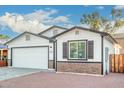 Newly built home with white siding, brick accents, and a two-car garage at 1217 S Desert View Pl, Apache Junction, AZ 85120