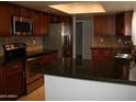 Kitchen with dark wood cabinets and granite countertops at 1231 E Helena Dr, Phoenix, AZ 85022