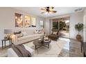 Living room with beige sofa, brown armchair, and patio access at 12947 W Chapala Dr, Sun City West, AZ 85375