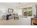 Spacious living room featuring a sliding glass door leading to a patio at 14203 W Rico Dr, Sun City West, AZ 85375