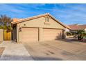 Two-car garage with tan stucco exterior and paved driveway at 16813 S 37Th Way, Phoenix, AZ 85048