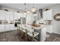 Spacious kitchen with white cabinets, breakfast bar, and stainless steel appliances at 19024 W Solano Dr, Litchfield Park, AZ 85340