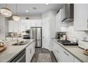 Modern kitchen with white cabinets, stainless steel appliances, and a large island at 19024 W Solano Dr, Litchfield Park, AZ 85340