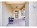 Covered entryway with wrought-iron security door and seating area at 19607 N Conquistador Dr, Sun City West, AZ 85375