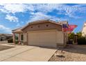 House exterior with tan walls, two-car garage, and American flag at 22516 N Via De La Caballa --, Sun City West, AZ 85375