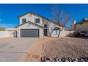 Two story home with gray garage door and landscaped yard at 2513 N 90Th Ln, Phoenix, AZ 85037