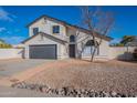 Two story home with gray garage door and landscaped yard at 2513 N 90Th Ln, Phoenix, AZ 85037