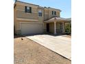 Two story house with tan exterior, two car garage, and covered entryway at 25527 W Burgess Ln, Buckeye, AZ 85326