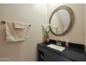 Small bathroom boasts an oval mirror and modern vanity with dark countertop at 277 E Windsor Ct, Gilbert, AZ 85296