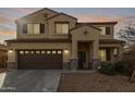 Two-story house with a brown double garage door and stone accents at 39979 W Robbins Dr, Maricopa, AZ 85138