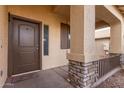 Front porch entry with stone pillars and brown door at 39979 W Robbins Dr, Maricopa, AZ 85138