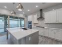 Modern kitchen with white cabinets, gray island, and herringbone backsplash at 4137 E Ronald St, Gilbert, AZ 85295