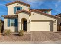 Charming two-story home featuring a red tile roof, blue shutters, and a brick driveway at 5629 S Veneto --, Mesa, AZ 85212