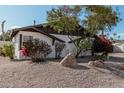 White single story home with mature trees and rock landscaping at 6409 W Orange Dr, Glendale, AZ 85301