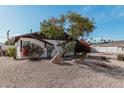 White single story home with mature trees and rock landscaping at 6409 W Orange Dr, Glendale, AZ 85301