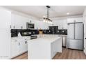 Modern kitchen with white cabinets and a large island at 6409 W Orange Dr, Glendale, AZ 85301