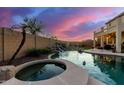 Inviting pool and spa with waterfall feature at sunset at 7409 W Briles Rd, Peoria, AZ 85383