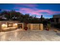 Evening view of a backyard patio with a fireplace and water feature at 9270 E Thompson Peak Pkwy # 335, Scottsdale, AZ 85255