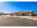 Single-story home with neutral exterior, two-car garage, and landscaping at 9316 S 39Th Dr, Laveen, AZ 85339