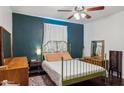 Relaxing bedroom with a green metal bed frame and dark-green accent wall at 1614 W Lynwood St, Phoenix, AZ 85007