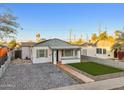 Cute bungalow with a charming front porch and well-manicured lawn at 1614 W Lynwood St, Phoenix, AZ 85007