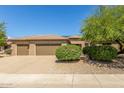 Three-car garage and front yard with drought-tolerant landscaping at 17311 N Havasupai Dr, Surprise, AZ 85374