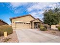 Tan house with a two-car garage and front porch at 22568 W Gardenia Dr, Buckeye, AZ 85326