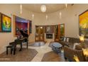 Spacious living room with a fireplace, large windows, and a piano at 25555 N Wrangler Rd, Scottsdale, AZ 85255