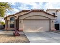 Tan house with a two-car garage and desert landscaping at 2625 N 110Th Dr, Avondale, AZ 85392