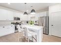 Modern kitchen with white cabinets, stainless steel appliances and breakfast bar at 35321 W Santa Monica Ave, Maricopa, AZ 85138