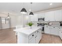 Bright kitchen featuring white cabinets, an island, and stainless steel appliances at 35321 W Santa Monica Ave, Maricopa, AZ 85138