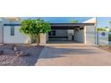 Mid-century home with carport and a landscaped front yard at 8642 E Monterosa Ave, Scottsdale, AZ 85251