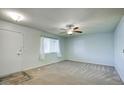 Living room featuring light walls, neutral carpeting and a window with curtains at 9841 N Balboa Dr, Sun City, AZ 85351