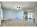 Bright living room with light walls, neutral carpeting, and ceiling fan at 9841 N Balboa Dr, Sun City, AZ 85351